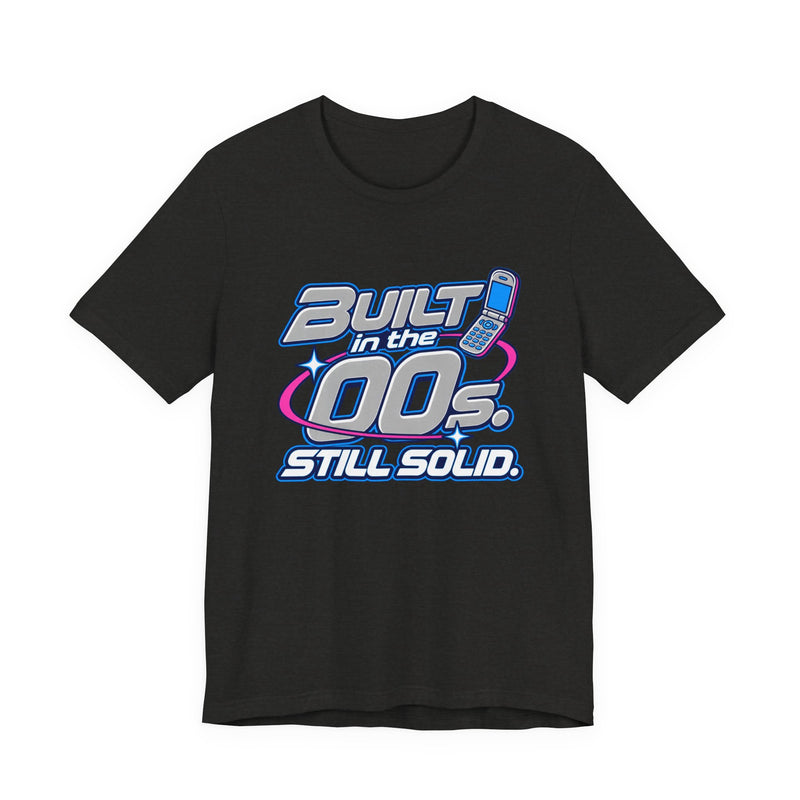 Built in the 00s. Still Solid Tee in Black Heather, front view with Y2K chrome-style lettering