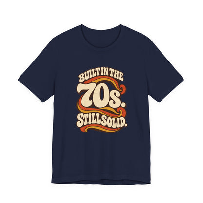 Built in the 70s. Still Solid Tee in Navy, front view with retro 70s lettering